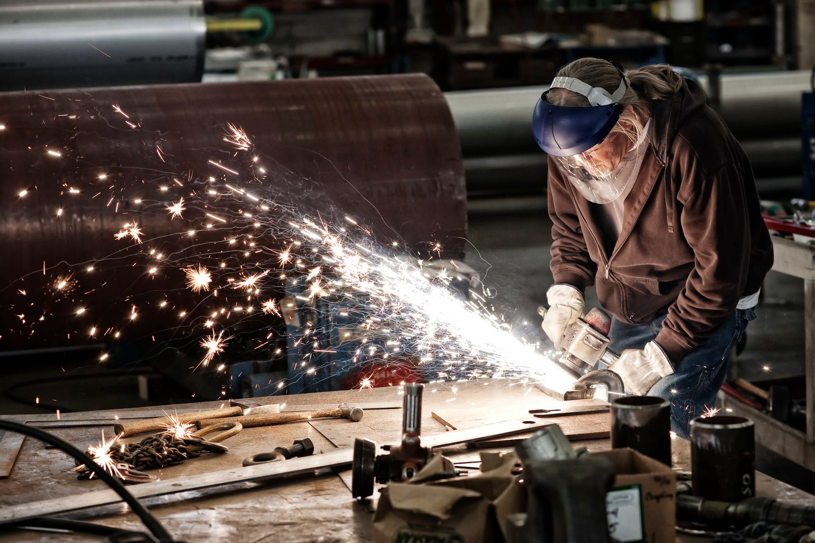 factory worker grinding a steel edge in a sheet metal factory 1 1